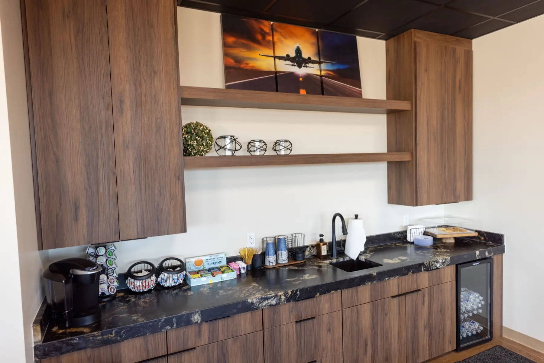 Guest refreshment station with coffee, snacks, and bottled water at Sandstone Aviation.